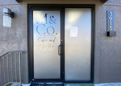 etched vinyl applied to double doors with cut out that reads "M & Co."