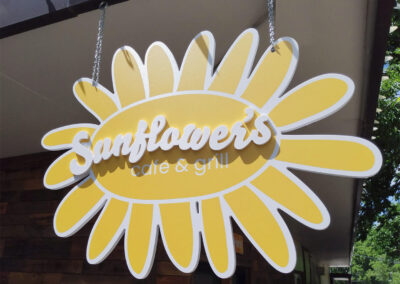 A sign cut in the shape of a sunflower with dimensional letters